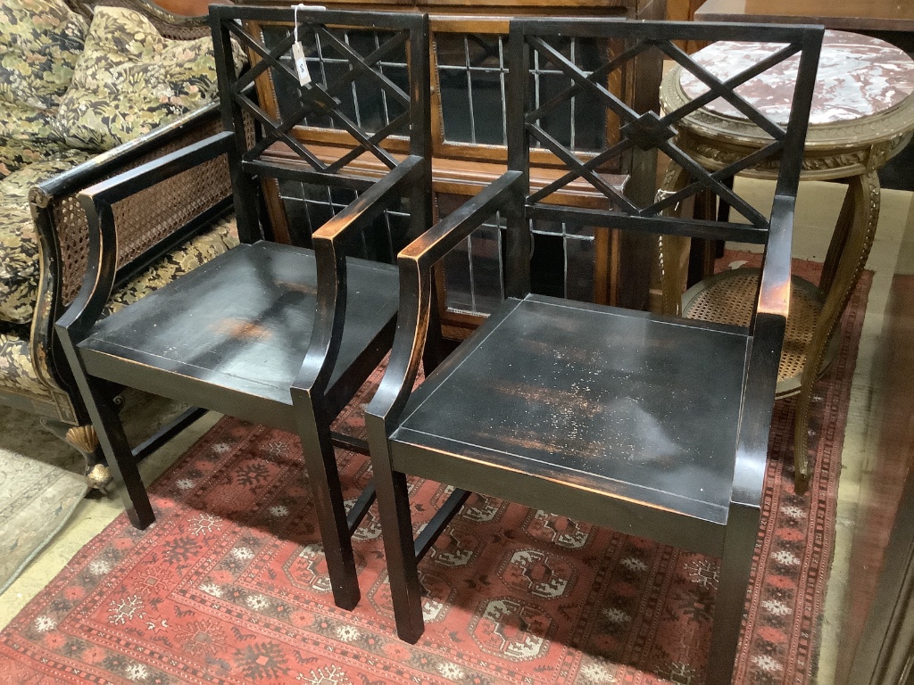 A pair of George III style ebonised elbow chairs
